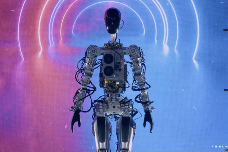 Īlons Masks prezentē strādājošu cilvēkveidīgo robotu, kas dejo uz skatuves